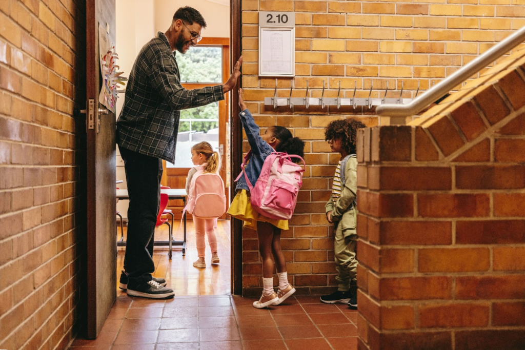 Male teacher greeting students